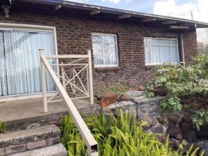 a brick house with a wooden staircase in front of it at Eagle Waters in Vanderkloof