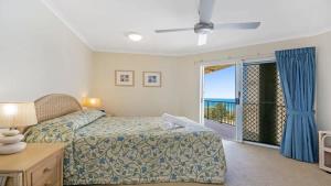 a bedroom with a bed and a view of the ocean at Pacific Waves Apartments in Noosa Heads