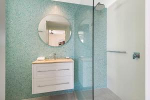 a bathroom with a sink and a mirror at Pacific Waves Apartments in Noosa Heads