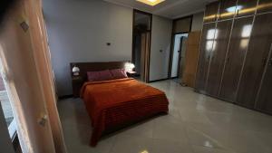 a bedroom with a bed with an orange blanket at Bishoftu Bliss in Debre Zeyit +3 photos