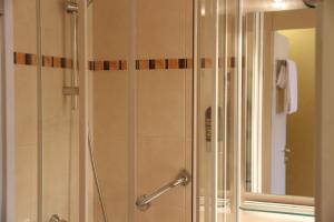 a shower with a glass door in a bathroom at TOP Hotel Amberger in Würzburg