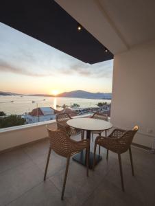 a table and chairs on a balcony with a view of the ocean at Apartments Soho in Trogir