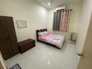 a small bedroom with a bed and a window at Rumah Inap Nik Atik in Cukai