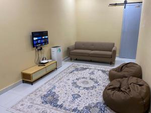 a living room with a couch and a tv at Rumah Inap Nik Atik in Cukai