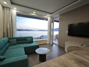 a living room with a green couch and a large window at Apartments Soho in Trogir