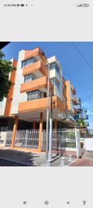 a tall building with a fence in front of it at Apartamento central melgar in Melgar