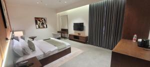 a hotel room with a bed and a television at Kiwa Banquet & Hotel in Koba