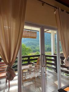 a balcony with sliding glass doors and a table and chairs at Nam Ou Breeze in Ban Ngoy-Nua
