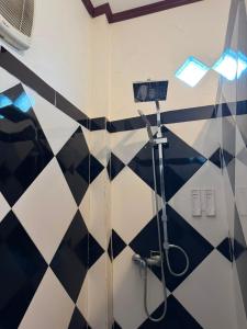 a bathroom with a shower with black and white tiles at Nam Ou Breeze in Ban Ngoy-Nua