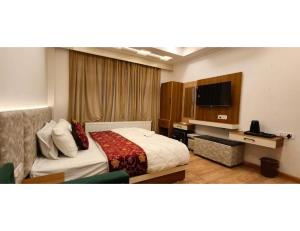 a hotel room with a bed and a television at Velour Pines Pahalgam in Pahalgām +26 photos