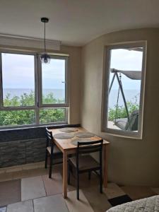a dining room with a table and two windows at Закоханий у море in Odesa