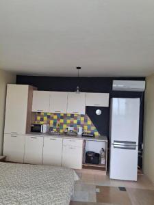 a kitchen with white cabinets and a white refrigerator at Закоханий у море in Odesa