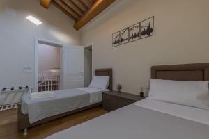 a bedroom with two beds with white sheets at Antica Corte Lugo in Lugo