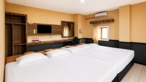 a large bed with white pillows in a room at Ventions Sharia Hotel in Jomblang