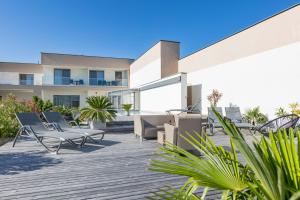a deck with chairs and tables on a building at Gut Leithaberg in Jois