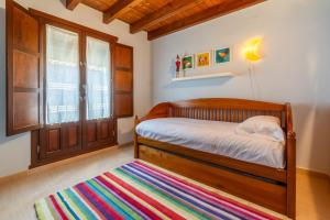 a bedroom with a wooden bed and a colorful rug at Casa PETRONILA in Lerma