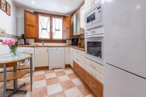 a kitchen with white cabinets and a table with a vase of flowers at Casa PETRONILA in Lerma +11 photos