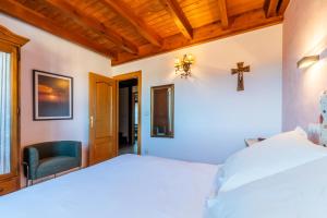 a bedroom with a bed and a cross on the wall at Casa PETRONILA in Lerma