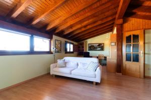 a living room with a white couch and a wooden ceiling at Casa PETRONILA in Lerma