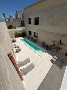 a patio with lounge chairs and a swimming pool at Corte Dei Francesi in Maglie