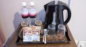 a tray with a tea kettle and bottles of water at Hotel 165 in Singapore