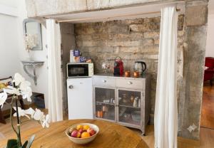 a kitchen with a table with a bowl of fruit at CHEZ LOU - Grand espace cosy 60 m2 entrée indépendante dans maison privée au calme in Bucey-lès-Gy