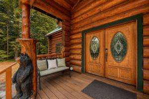 a cabin with a wooden door and a chair on a porch at Soaring Pines Lodge by NW Comfy Cabins in Leavenworth
