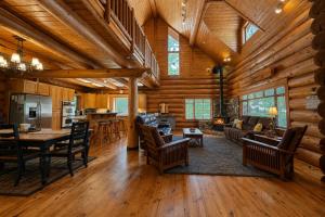 a living room with wooden ceilings and a dining and living room at Soaring Pines Lodge by NW Comfy Cabins in Leavenworth