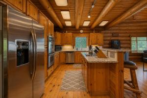 a kitchen with a stainless steel refrigerator and wooden cabinets at Soaring Pines Lodge by NW Comfy Cabins in Leavenworth +63 photos