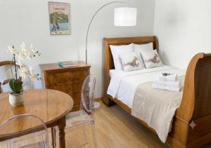 a small bedroom with a bed and a table at CHEZ LOU - Grand espace cosy 60 m2 entrée indépendante dans maison privée au calme in Bucey-lès-Gy