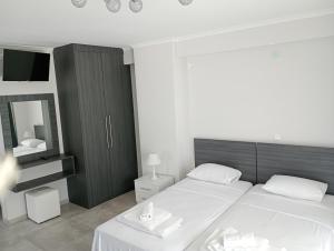 a bedroom with two beds and a mirror at Alivka Apartments in Apolpaina