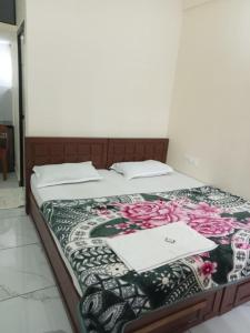 a bed with two sheets and two papers on it at Hotel Diamond Castle in Manjeri +10 photos