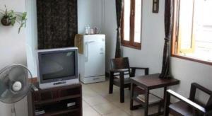 a living room with a television and a refrigerator at Sritrang Hotel in Trang +47 photos