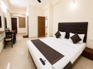 a bedroom with a large bed and a table at Hotel Elite Stay in Bori +13 photos