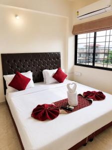a bedroom with a large bed with red pillows at Hotel Elite Stay in Bori