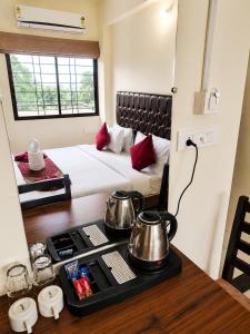 a room with a bed and a table with pots and pans at Hotel Elite Stay in Bori