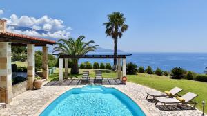 a swimming pool in a backyard with a view of the ocean at Villa Dimitra in Trapezaki