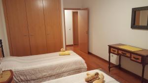 1 dormitorio con 2 camas, mesa y espejo en AH Leiria apartment, en Leiria