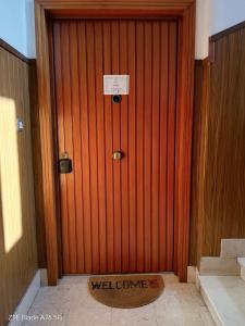 a wooden door with a welcome mat in front of it at Casa Alba in Taranto