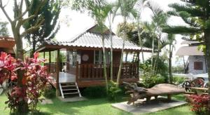 a small house with a porch and a statue in the yard at Mossview Resort in Khao Kho