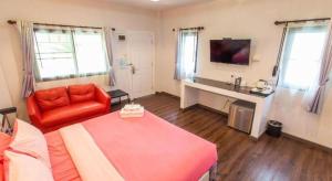 a bedroom with a bed and a couch and a desk at Mossview Resort in Khao Kho