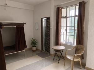 a room with a bed and a table and a chair at Naga Hills Backpacker Hostel in Kohīma