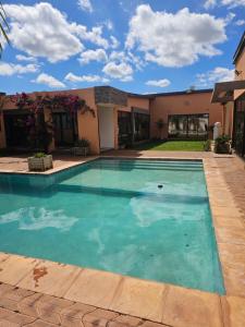 a swimming pool in front of a house at Luxe Apartments in Lusaka