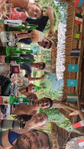 a group of people posing for a picture with wine bottles at Batu Katak Jungle River & Trekking in Bukit Lawang