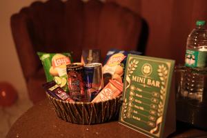 a basket of chips and snacks on a table with a bottle of water at Hotel Clover in Zirakpur
