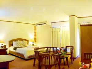 a bedroom with a bed and a table and chairs at Phuphaya Resort Pattaya in Pattaya South +194 photos