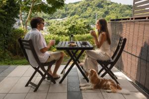 a man and woman sitting at a table with a dog at Kamakura Jomyoji Terrace-鎌倉浄明寺テラス- in Kamakura