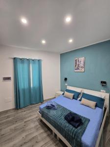 a bedroom with a large bed with a blue wall at Isabel House in Capoterra