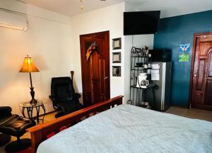 a bedroom with a bed and a chair and a refrigerator at Los Mangoes in Hopkins +66 photos