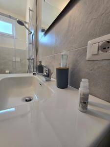 a bathroom sink with a bottle of soap on it at Isabel House in Capoterra